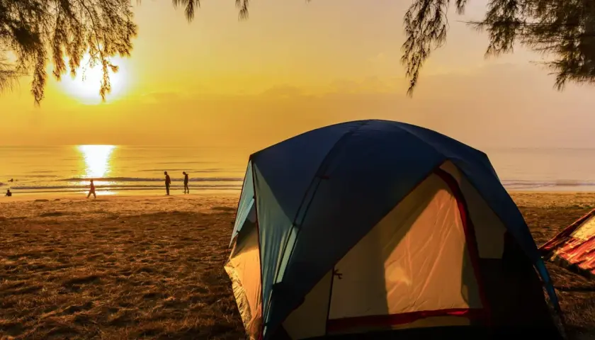 Namiot na plaży o zachodzie słońca. Idealne miejsce na tanie kempingi nad morzem, gdzie można podziwiać piękno natury.