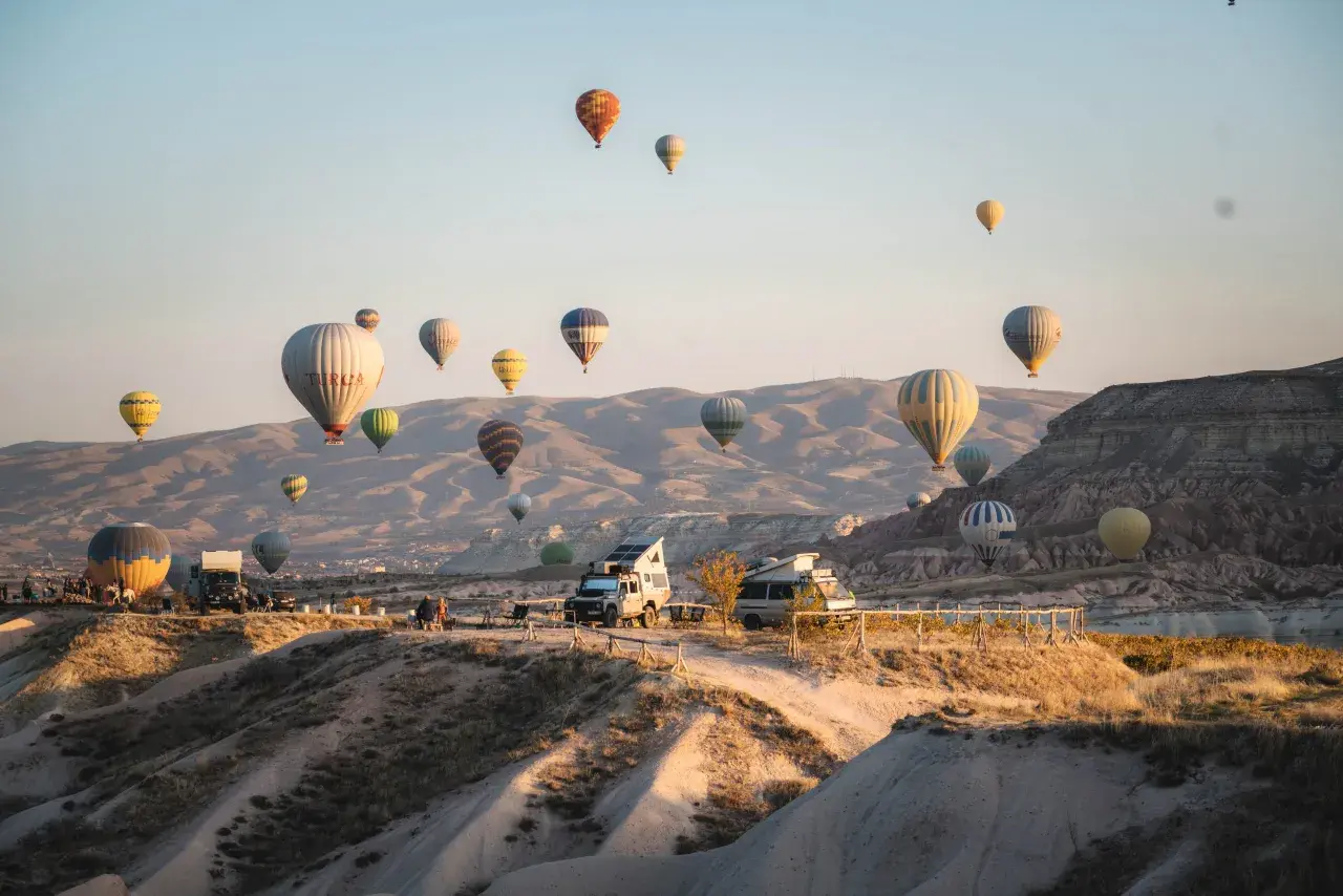 Balony unoszą się nad skalistym krajobrazem Kapadocji w Turcji, tworząc magiczny widok.