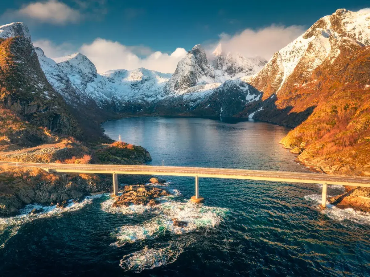 Mosty nad fiordem, ośnieżone góry, złote światło. Idealny czas na podróż do Norwegii to jesień, kiedy krajobraz jest tak piękny.