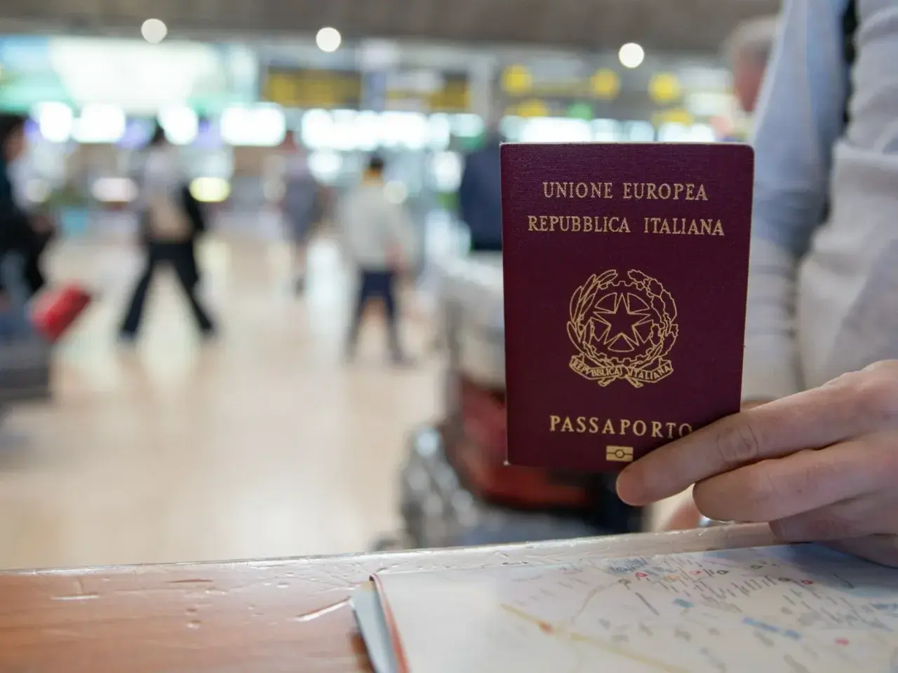 Włoski paszport w dłoni, gotowy do podróży po krajach bez paszportu w strefie Schengen.