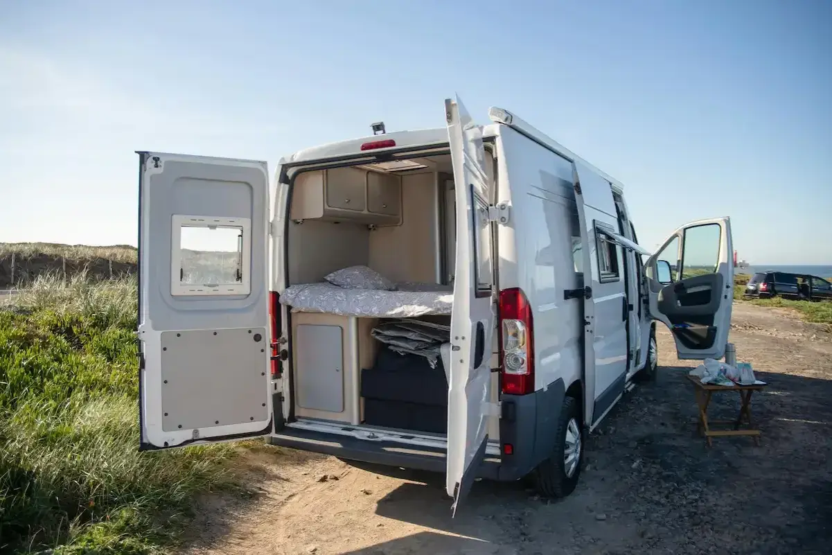 Trzy Mitsubishi L300 Delica D:5 w różnych kolorach i wersjach, na białym tle.