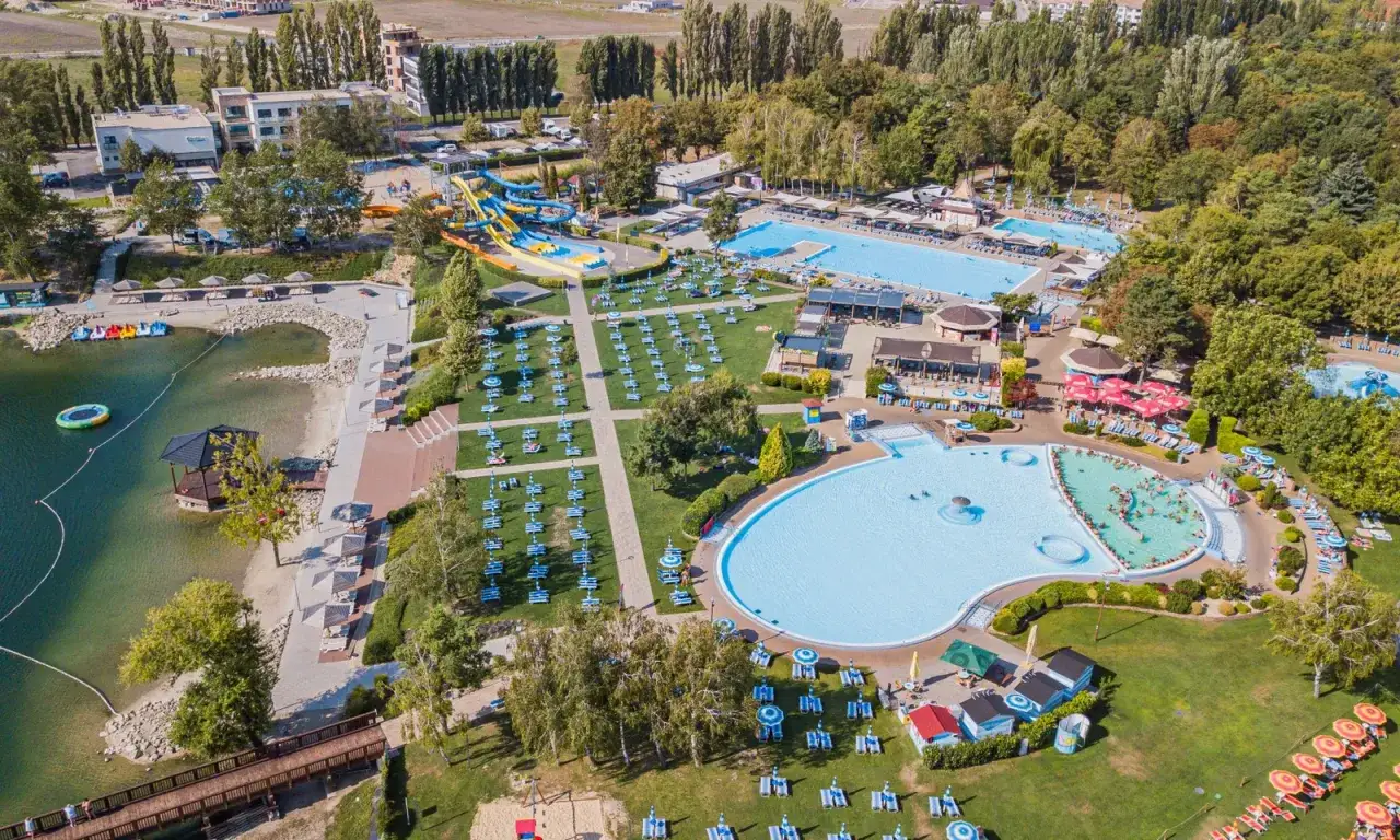 Widok z lotu ptaka na kompleks wodny z basenami, zjeżdżalniami i plażą. Idealne miejsce na rodzinny wypoczynek, jak w najlepszym dunajska streda camping.