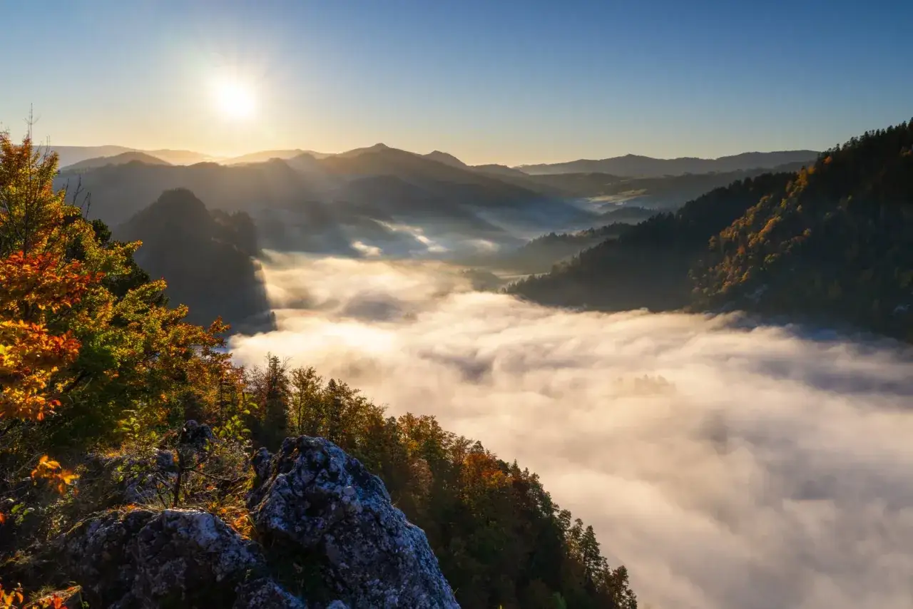 Poranek w Tatrach. Mgły spowijają doliny, słońce wschodzi nad górami. Idealne miejsce na camping Tatry.