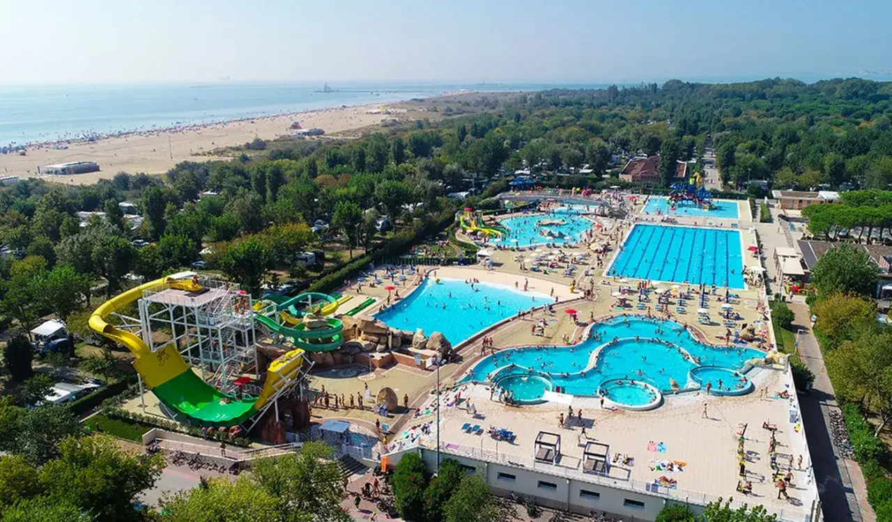 Wodne szaleństwo na Marina di Venezia camping! Mnóstwo basenów, zjeżdżalni i plaża w tle. Idealne miejsce na wakacje.