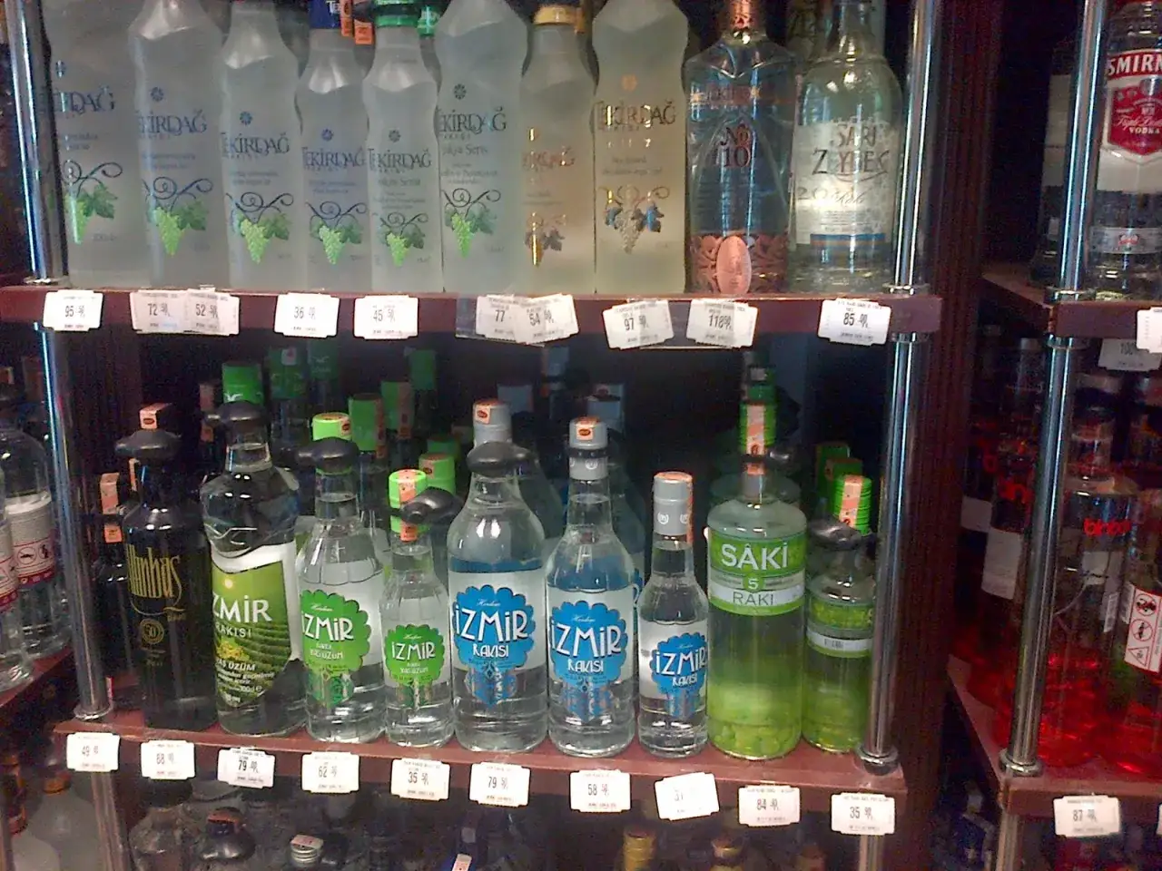 Raki i inne alkohole w Turcji na półkach sklepowych. Butelki z napisem